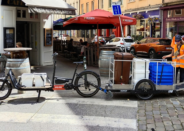 Une collectrice de OuiCompost charge la remorque vélo suite à une collecte de biodéchets effectuée chez un client profesionnel à Lyon.