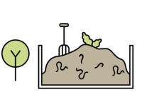 Un tas de compost avec une fourche plantée en plein milieu du tas et une feuille de salade en haut du tas. Un arbre pousse à côté du bac  où est stocké le tas de compost.