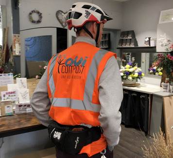 Collecteur OuiCompost entrant dans une boutique de fleuriste à Lyon pour récupérer des déchets verts dans le cadre d’un service clé en main de gestion des déchets alimentaires